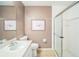 Bathroom with framed art, a toilet, a shower with a sliding door, and a sink at 2015 Gardenia Landings Ln, Sun City Center, FL 33573