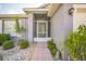 Inviting front entry with a white security door, lush landscaping, and a tiled walkway to the front door at 2015 Gardenia Landings Ln, Sun City Center, FL 33573