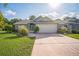 Charming single-story home featuring a well-manicured lawn and a two-car garage with ample parking space at 2015 Gardenia Landings Ln, Sun City Center, FL 33573