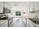 Bright kitchen with white cabinetry, stainless steel appliances, and an open layout connecting to the dining area at 2015 Gardenia Landings Ln, Sun City Center, FL 33573