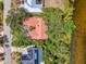 Expansive aerial view reveals a waterfront property with lush tree cover, solar panels, and unique architectural details at 2504 Tanglewood Dr, Sarasota, FL 34239