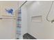 Updated bathroom with white textured walls, accent art, and decorative shower curtain at 2504 Tanglewood Dr, Sarasota, FL 34239