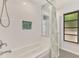 Modern bath with soaking tub, shower, tile accent, and window at 2504 Tanglewood Dr, Sarasota, FL 34239