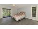 Bedroom with a floral bedspread and sliding door access to a patio with a lake view at 2504 Tanglewood Dr, Sarasota, FL 34239