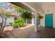 Charming courtyard with lush greenery and a vibrant blue front door, creating a welcoming entrance at 2504 Tanglewood Dr, Sarasota, FL 34239