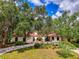 Charming single-story home with a red tile roof, lush landscaping, and a welcoming arched entryway at 2504 Tanglewood Dr, Sarasota, FL 34239