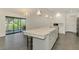 Kitchen and living room with a granite-topped island, modern appliances, and an adjacent screened porch at 2504 Tanglewood Dr, Sarasota, FL 34239