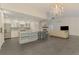 Open-concept living room with stone fireplace, chandelier, and kitchen island with bar seating at 2504 Tanglewood Dr, Sarasota, FL 34239