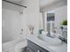 Modern bathroom with clean white tiles, sleek vanity, and a combined bathtub and shower at 12829 Kings Lake Dr, Gibsonton, FL 33534