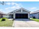 Charming single-story home featuring a well-maintained lawn, grey paint, and a spacious two-car garage at 12829 Kings Lake Dr, Gibsonton, FL 33534