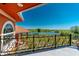 Balcony view of the property with ornamental iron railing overlooking beautiful lush greenery and a tranquil lake at 37511 Washington Loop Road, Punta Gorda, FL 33982