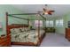 Spacious bedroom with a four-poster bed, a ceiling fan, and plantation shutters at 37511 Washington Loop Road, Punta Gorda, FL 33982