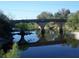 Beautiful view of concrete bridge arches reflected over peaceful river surrounded by lush green foliage at 37511 Washington Loop Road, Punta Gorda, FL 33982