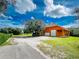 Exterior angle showing house, garage, open bay and expansive lawn at 37511 Washington Loop Road, Punta Gorda, FL 33982