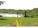 Scenic view of the pond featuring a great blue heron standing peacefully on the green lawn, and solar panel at 37511 Washington Loop Road, Punta Gorda, FL 33982
