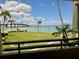 Balcony view showcasing a lawn, pool, bridge, and clear blue ocean at 115 1St E St # 103, Tierra Verde, FL 33715