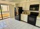 Modern kitchen with black appliances, white cabinets, and balcony access at 115 1St E St # 103, Tierra Verde, FL 33715