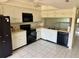 Bright kitchen features white cabinets, black appliances, and tile floors at 115 1St E St # 103, Tierra Verde, FL 33715