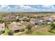 Scenic aerial shot featuring the house in a neighborhood with lush greenery and a clear blue sky at 12784 Burns Dr, Odessa, FL 33556