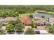 Beautiful aerial view of the home with its well-manicured lawn, mature trees, and proximity to a serene lake at 12784 Burns Dr, Odessa, FL 33556