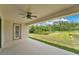 Cozy covered patio with ceiling fan overlooking a well-maintained yard and a serene lake at 12784 Burns Dr, Odessa, FL 33556
