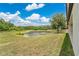 Expansive backyard with lush green lawn and tranquil lake views on a sunny day at 12784 Burns Dr, Odessa, FL 33556