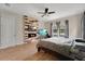Comfortable bedroom with a wood-accent wall, two TVs, a ceiling fan, and natural light from the windows at 12784 Burns Dr, Odessa, FL 33556