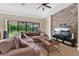 Comfortable living room featuring a stone accent wall, and ample natural light from the sliding glass doors at 12784 Burns Dr, Odessa, FL 33556