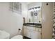 Well-lit bathroom with a modern vanity featuring a black countertop and white cabinets at 4549 Tippecanoe Trl # 20, Sarasota, FL 34233