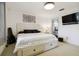 Well-lit bedroom showcases a white bed with storage, abstract wall art, and an ensuite bathroom at 4549 Tippecanoe Trl # 20, Sarasota, FL 34233