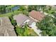 Overhead shot of a well-maintained single-Gathering home with a tile roof and lush landscaping near a pond at 6504 Virginia Xing, University Park, FL 34201