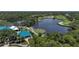 Aerial view showcasing a golf course with a lake, set amongst lush greenery and residential homes at 6504 Virginia Xing, University Park, FL 34201