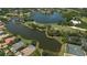 Aerial view of a golf course community featuring a lake, greens, and homes with private pools at 6504 Virginia Xing, University Park, FL 34201