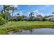 A spacious backyard with lush landscaping, a pond, and views of neighboring homes at 6504 Virginia Xing, University Park, FL 34201