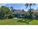 Backyard view featuring lush landscaping, lawn, and screened lanai with lounge chairs at 6504 Virginia Xing, University Park, FL 34201