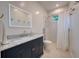 Stylish bathroom with a vanity, a modern mirror, a shower with curtain and marble countertops at 6504 Virginia Xing, University Park, FL 34201