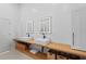 Contemporary bathroom featuring double sinks, sleek fixtures, wooden shelving, and ample storage space at 6504 Virginia Xing, University Park, FL 34201