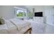 Bright bedroom featuring a large window with scenic views, white bedding, and modern furnishings at 6504 Virginia Xing, University Park, FL 34201