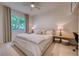 Serene bedroom with a ceiling fan, a large window overlooking greenery, and a cozy workspace at 6504 Virginia Xing, University Park, FL 34201