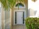 An elegant front door with sidelights and a transom window, surrounded by landscaping at 6504 Virginia Xing, University Park, FL 34201