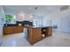 Spacious kitchen featuring wood cabinets, granite countertops, central island, and stainless steel appliances at 6504 Virginia Xing, University Park, FL 34201