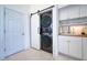 Laundry room with stacked washer/dryer, white cabinets, wood countertops, and sliding barn door at 6504 Virginia Xing, University Park, FL 34201