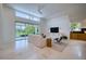 An open living room with a high ceiling, a modern ceiling fan, and a large window at 6504 Virginia Xing, University Park, FL 34201
