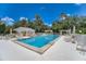 Inviting pool area with ample lounge chairs, umbrellas, and a covered patio, perfect for relaxation at 6504 Virginia Xing, University Park, FL 34201