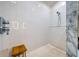Luxurious shower with white tiles, a wooden bench, and marble accents, offering a spa-like experience at 6504 Virginia Xing, University Park, FL 34201