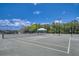 Well-maintained community tennis court with a shaded viewing area on a sunny day at 6504 Virginia Xing, University Park, FL 34201
