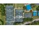 Overhead view of multiple tennis courts surrounded by lush landscaping, offering a recreational amenity at 6504 Virginia Xing, University Park, FL 34201