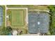 Aerial view featuring well-maintained tennis and pickleball courts surrounded by landscaped grounds at 6504 Virginia Xing, University Park, FL 34201