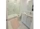 This modern bathroom is designed with marble tiling, a glass enclosed shower, and sleek white fixtures at 4309 W Beachway Dr, Tampa, FL 33609
