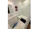 Modern bathroom with a marble-tiled shower, white vanity, and stylish shark-themed rug for a playful touch at 4309 W Beachway Dr, Tampa, FL 33609